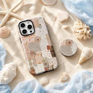 May include: A rectangular smartphone case and a circular phone grip featuring a patchwork design of various floral, plaid, and heart patterns in shades of beige, brown, cream, and soft orange. The case has a black camera cutout for three lenses.