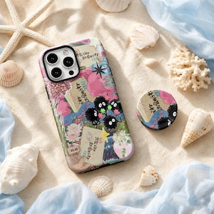 May include: A smartphone case and a matching circular phone grip featuring a collage of pink flowers, green foliage, and black soot sprites. The design includes Japanese text, a hand holding a ticket, and a small $5.00 price tag graphic.