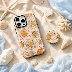 May include: A rectangular smartphone case and a circular phone grip featuring a repeating pattern of stylized suns with smiling faces in shades of yellow, orange, and dark blue on a light cream background, arranged with various seashells.