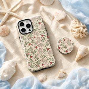 May include: A rectangular smartphone case and a circular phone grip featuring a cream background with a repeating pattern of green leaves and small red berries. The case has a black camera cutout area with three circular lenses.