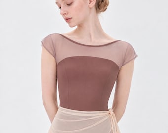 May include: A brown leotard featuring a sheer mesh overlay across the upper chest and shoulders, creating a boat neckline with cap sleeves. The bodice is constructed from a solid, opaque fabric, paired with a sheer, light beige wrap skirt.