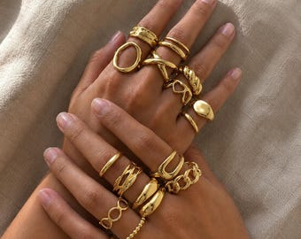 Goudkleurige stapelbare ringen, een mix van grove en minimalistische vormen.