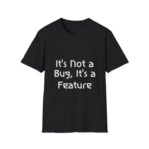 Könnte beinhalten: Ein schwarzes Kurzarm-T-Shirt mit dem weißen Text "It's Not a Bug, It's a Feature", der in einer klaren serifenlosen Schrift mittig auf der Brust aufgedruckt ist. Das Kleidungsstück hat einen klassischen Rundhalsausschnitt und einen geraden Saum.