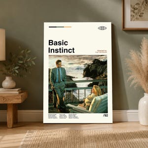 May include: A vertical rectangular poster for the film Basic Instinct featuring the title in bold black text, the director Paul Verhoeven, and a central photographic scene of a person in a suit standing near a person seated on a balcony.
