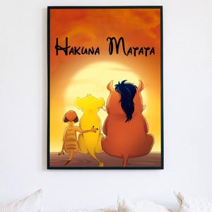 Op de afbeelding: Een ingelijste kunstdruk met een zonsondergangscène waarop een stokstaartje, een leeuwenwelp en een wrattenzwijn samen zitten. De tekst "Hakuna Matata" staat in zwarte letters boven de figuren tegen een felgele en oranje luchtachtergrond.