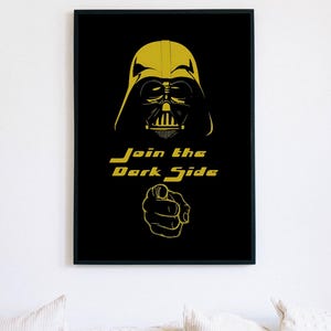 Può includere: Una stampa da parete rettangolare incorniciata che presenta una grafica gialla di un personaggio con casco sopra il testo Join the Dark Side e un dito che punta, il tutto su uno sfondo nero solido all'interno di una sottile cornice nera.