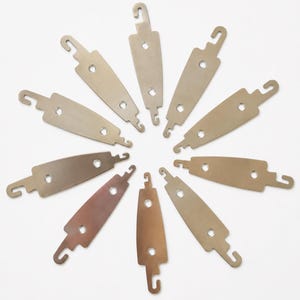 May include: A collection of ten metallic, elongated, flat components arranged in a circular pattern. Each piece features a central body with two circular holes and distinct hook-shaped ends extending from opposite sides, finished in a smooth, silver-toned metal.