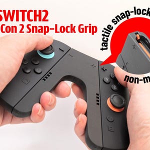 Könnte beinhalten: Ein schwarzer Joy-Con 2 Snap-Lock Grip Controller-Aufsatz mit einem taktilen, nicht-magnetischen Einrastsystem. Das Gerät verfügt über einen hellblauen Joystick auf der linken und einen orangefarbenen Joystick auf der rechten Seite.