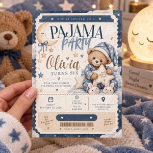 Könnte beinhalten: Eine rechteckige Einladungskarte für eine Schlafanzugparty mit einem Teddybären im blauen Schlafanzug, einem Halbmond und Sternen. Der Text enthält 'You're invited to a Pajama Party', 'Olivia turns six', Veranstaltungsdetails für den 14. Januar 2028.