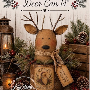 Puede incluir: Una lata decorativa de 35,5 cm de altura con una cabeza de ciervo de tela color canela, astas de ramitas y una bufanda de arpillera. La lata muestra una ilustración de Santa Claus con el texto MERRY CHRISTMAS y una etiqueta SANTA'S HELPER.