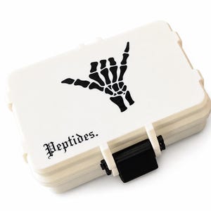 May include: A rectangular white storage case with a black latch and a black graphic of a skeleton hand making a shaka sign. The word Peptides. is printed in a black gothic-style font on the lower left corner of the lid of the storage container.