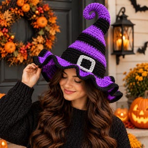 May include: A crocheted witch hat featuring alternating horizontal stripes of vibrant purple and black yarn. The hat has a tall, pointed, slightly curled top and a wide, ruffled brim. A silver-coloured square buckle is attached to the front base.