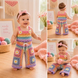 May include: A two-piece crochet outfit featuring a rainbow-coloured top and wide-leg trousers with white daisy granny square motifs. The set includes a matching pink headband with a bow. The top and trousers have scalloped edges and a white drawstring.