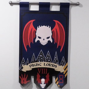May include: A dark blue vertical fabric banner hanging from a silver rod. The design features a large white skull with red bat wings, a banner scroll with the text NIGHT LORDS, the Roman numeral VIII, a red handprint, and a smaller skull emblem.
