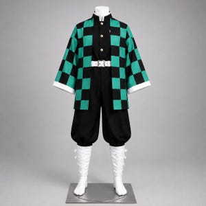 May include: A costume set featuring a black long-sleeve jacket and matching pants, paired with a green and black checkered haori. The outfit includes a white belt with a silver buckle and white leg wraps, displayed on a mannequin against a gray background.
