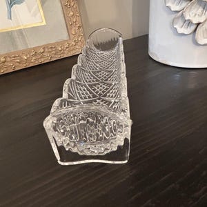 Peut inclure: Un plat à céleri en verre transparent présentant une forme longue et rectangulaire avec un bord festonné et un motif détaillé en diamant sur les côtés. Le verre possède une base épaisse et robuste ainsi qu'une surface réfléchissante.