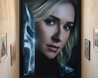 Op de afbeelding: Een ingelijste rechthoekige wandkunstprint met een close-up portret van een blond persoon met donkere ogen, geplaatst naast de reflectie van een spookachtig, metalen masker op een scherp mes. Zwarte lijst.