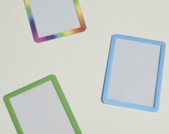 May include: Three rectangular magnetic frames with white centers. One frame features a rainbow gradient border, one is solid light blue, and one is solid light green. Each frame has rounded corners and a flat, smooth surface finish.