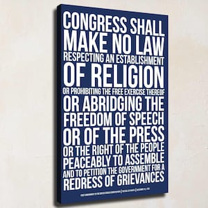 May include: A rectangular canvas wall art piece featuring a deep blue background with bold white text displaying the First Amendment of the United States Constitution. The text reads: CONGRESS SHALL MAKE NO LAW RESPECTING AN ESTABLISHMENT OF RELIGION OR PROHIBITING THE FREE EXERCISE THEREOF OR ABRIDGING THE FREEDOM OF SPEECH OR OF THE PRESS OR THE RIGHT OF THE PEOPLE PEACEABLY TO ASSEMBLE AND TO PETITION THE GOVERNMENT FOR A REDRESS OF GRIEVANCES.