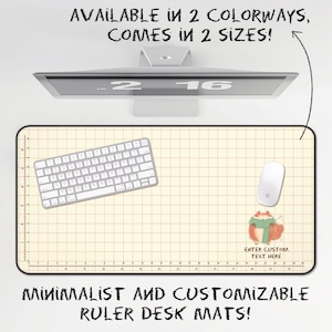 May include: A rectangular desk mat with a cream-colored grid pattern and a ruler border. The mat features a small illustration of a fox wearing a green scarf and the text "ENTER CUSTOM TEXT HERE". The text "AVAILABLE IN 2 COLORWAYS, COMES IN 2 SIZES!" and "MINIMALIST AND CUSTOMIZABLE RULER DESK MATS!" appear above and below the mat.
