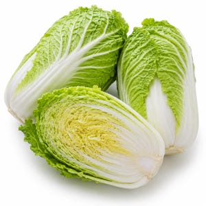 May include: Two whole heads of napa cabbage and one halved head of napa cabbage. The vegetables feature crinkled, light green leaves at the top that transition into thick, smooth, white stalks at the base. The cross-section reveals pale yellow layers.