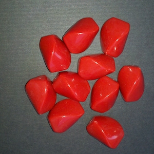 May include: Ten red, faceted, heart-shaped beads. The beads are made of a smooth, shiny material.