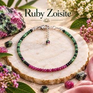 Könnte beinhalten: Ein Perlenarmband mit facettierten Rubin-Zoisit-Steinen in den Farben Dunkelrosa, Waldgrün und Schwarz. Das Armband verfügt über einen silberfarbenen Karabinerverschluss, eine verstellbare Verlängerungskette und eine einzelne hängende Rubin-Zoisit-Perle.