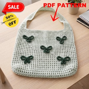 May include: A light green crocheted tote bag featuring a grid-like open weave pattern and five dark green crocheted bow appliques attached to the front. The bag includes a single integrated handle and the text PDF PATTERN is visible above.