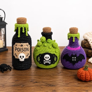 May include: Three crocheted potion bottles with brown corks. The first is black with a green drip, a label reading POISON, and a skull. The second is green with bubbles and a skull and crossbones label. The third is purple with a black bat.