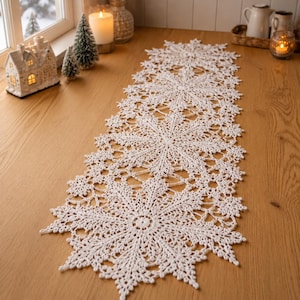 May include: A long, white, rectangular table runner crafted from intricate crochet lace. The design features a repeating pattern of large, detailed snowflake motifs connected by delicate openwork, creating a scalloped edge along the entire length.