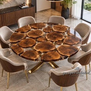 May include: A round dining table featuring multiple natural wood cross-section slices embedded in a clear resin top, supported by a gold-toned metal base. The set includes eight chairs with light beige upholstered seats and dark wood backs.