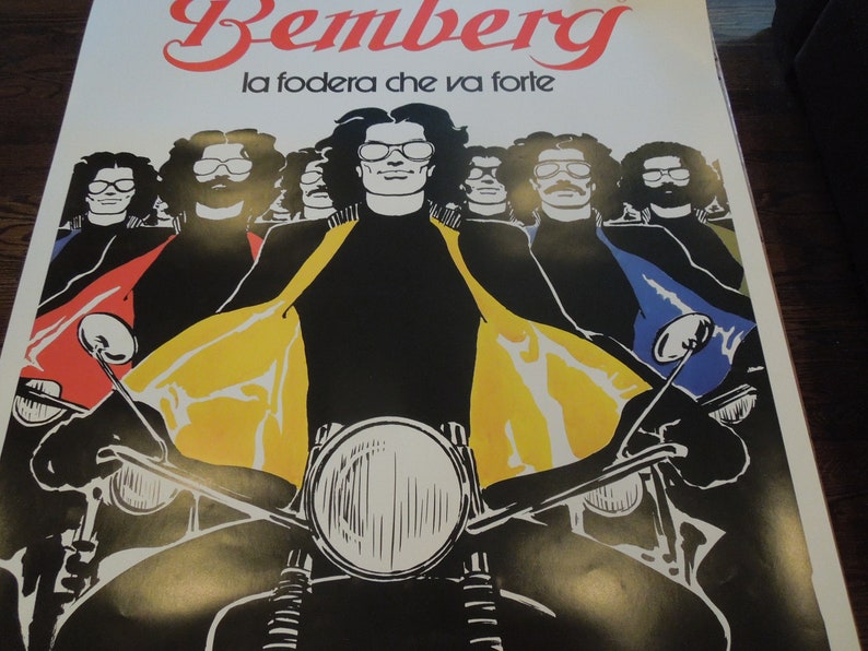 Pu&ograve; includere: Un poster vintage che pubblicizza il tessuto Bemberg con lo slogan "la fodera che va forte". Il poster presenta un gruppo di uomini con occhiali da sole che guidano motociclette. Gli uomini indossano giacche di pelle nere con accenti gialli, rossi e blu. Il poster ha un'estetica retr&ograve; degli anni '70.