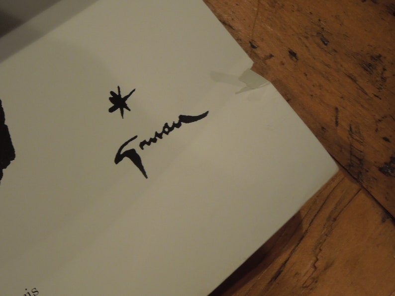 Pu&ograve; includere: Una firma in bianco e nero con il nome "Trueman" scritto in corsivo. Una piccola stella &egrave; sopra la firma.