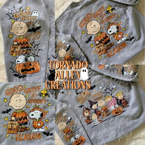 May include: A heather gray sweatshirt featuring a repeating Halloween-themed graphic print of cartoon characters, pumpkins, ghosts, and spiderwebs. The text reads Good Grief It's Spooky Season and Tornado Alley Creations in orange and black lettering.