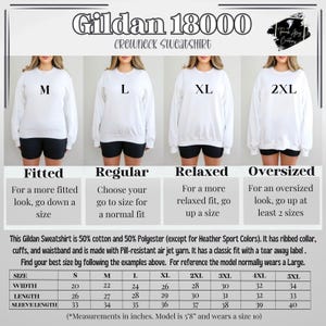 May include: A Gildan 18000 crewneck sweatshirt size chart featuring four white sweatshirts labeled M, L, XL, and 2XL. The chart includes fit descriptions, fabric composition, and a table with width, length, and sleeve length measurements in inches.
