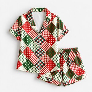 May include: A short-sleeve button-down pajama shirt and matching shorts set featuring a festive patchwork pattern. The design consists of alternating diamond-shaped blocks in red, green, and white, displaying motifs of pine trees, hearts, and stripes.