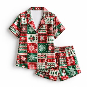 May include: A short-sleeve button-down pajama shirt and matching shorts set featuring a festive patchwork pattern in red, green, and white. The design includes repeating motifs of snowflakes, Christmas trees, and snowmen on a grid background.
