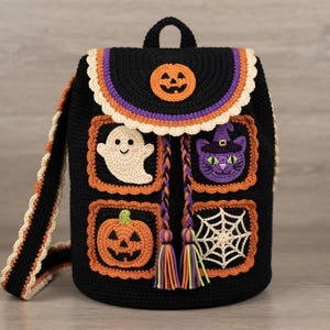 May include: A black crochet backpack featuring Halloween-themed motifs including a ghost, a purple cat in a witch hat, a pumpkin, and a spiderweb. The flap has a pumpkin emblem and a cream scalloped edge, with braided drawstrings and tassels.