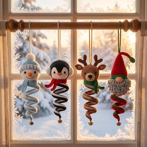 May include: Four crocheted hanging ornaments featuring a snowman in a blue hat and scarf, a penguin with earmuffs and a red scarf, a reindeer with a green scarf, and a gnome in a red hat, each ending in a small gold bell at the bottom.