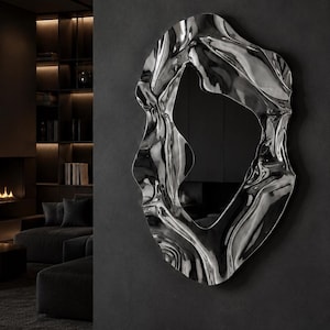 May include: A wall-mounted mirror featuring a highly reflective, polished silver frame with an irregular, organic, and fluid shape. The frame has deep, undulating curves and folds that create a distorted, liquid-like appearance around the central glass.