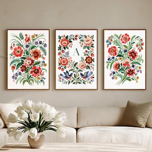 Könnte beinhalten: Drei rechteckige Wandbilder mit Blumenillustrationen auf weißem Hintergrund. Die linken und rechten Bilder zeigen lebendige Blumensträuße in Rot, Rosa und Blau mit grünem Blattwerk. Das mittlere Bild zeigt den Buchstaben A.