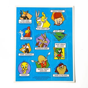 May include: A blue sheet of Looney Tunes stickers featuring Daffy Duck, Bugs Bunny, Elmer Fudd, Foghorn Leghorn, Wile E. Coyote, Road Runner, Sylvester, Marvin the Martian, Tweety, Yosemite Sam, and Taz with phrases like That's Using The Old Noodle.