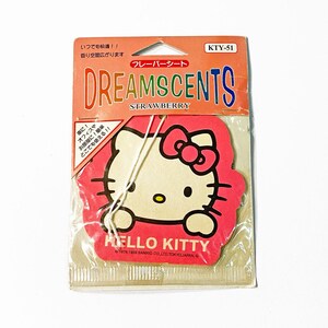 Puede incluir: Un ambientador con aroma a fresa de Hello Kitty en un embalaje de plástico transparente. El ambientador rosa y blanco presenta el personaje de Hello Kitty con el texto "DREAMSCENTS" y "STRAWBERRY". El paquete también incluye texto en japonés.