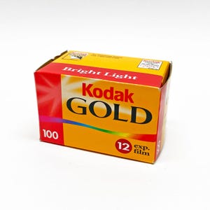 May include: A box of Kodak Gold 100 film. The box is yellow with red accents and features the Kodak logo and the words "Bright Light." It indicates 12 exposures.