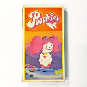 May include: Vintage rectangular box featuring the cartoon character Poochie. The box has a yellow border and an orange background with the word "Poochie" in pink script. The cartoon dog has pink hair and sunglasses.