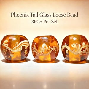 May include: Three amber-colored glass loose beads with a Phoenix Tail design, featuring swirling white and cream-colored patterns embedded within the glass. The text Phoenix Tail Glass Loose Bead 3PCS Per Set is displayed above the beads.