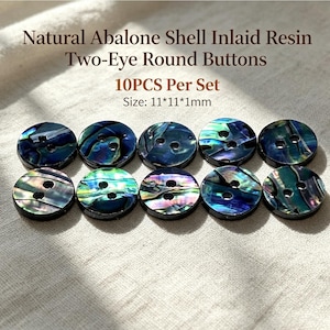 May include: A set of 10 round buttons featuring natural abalone shell inlaid in resin with two eye holes. The buttons display iridescent blue, green, and purple tones. Text on the image reads: Natural Abalone Shell Inlaid Resin Two-Eye Round Buttons 10PCS Per Set Size: 11*11*1mm.