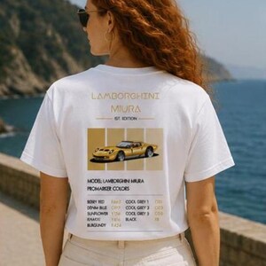 Pode incluir: Uma t-shirt branca de manga curta com um gr&aacute;fico nas costas contendo o texto Lamborghini Miura 1st Edition, uma ilustra&ccedil;&atilde;o de um carro desportivo amarelo e uma lista de cores Promarker incluindo Berry Red, Denim Blue, Sunflower, Khaki e Burgundy.