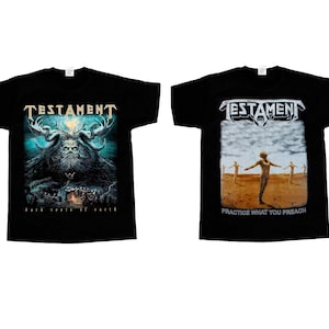 May include: Two black short-sleeve t-shirts. The left shirt features a blue-toned graphic of a horned figure and the text "TESTAMENT" and "DARK ROOTS OF EARTH". The right shirt displays a desert scene with figures and the text "TESTAMENT" and "PRACTICE WHAT YOU PREACH".