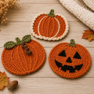 Peut inclure: Trois dessous de verre en crochet en forme de citrouilles. L'un présente une bordure crème, un autre des feuilles vertes et une tige brune, et le troisième affiche un visage de citrouille d'Halloween noir avec des yeux triangulaires.